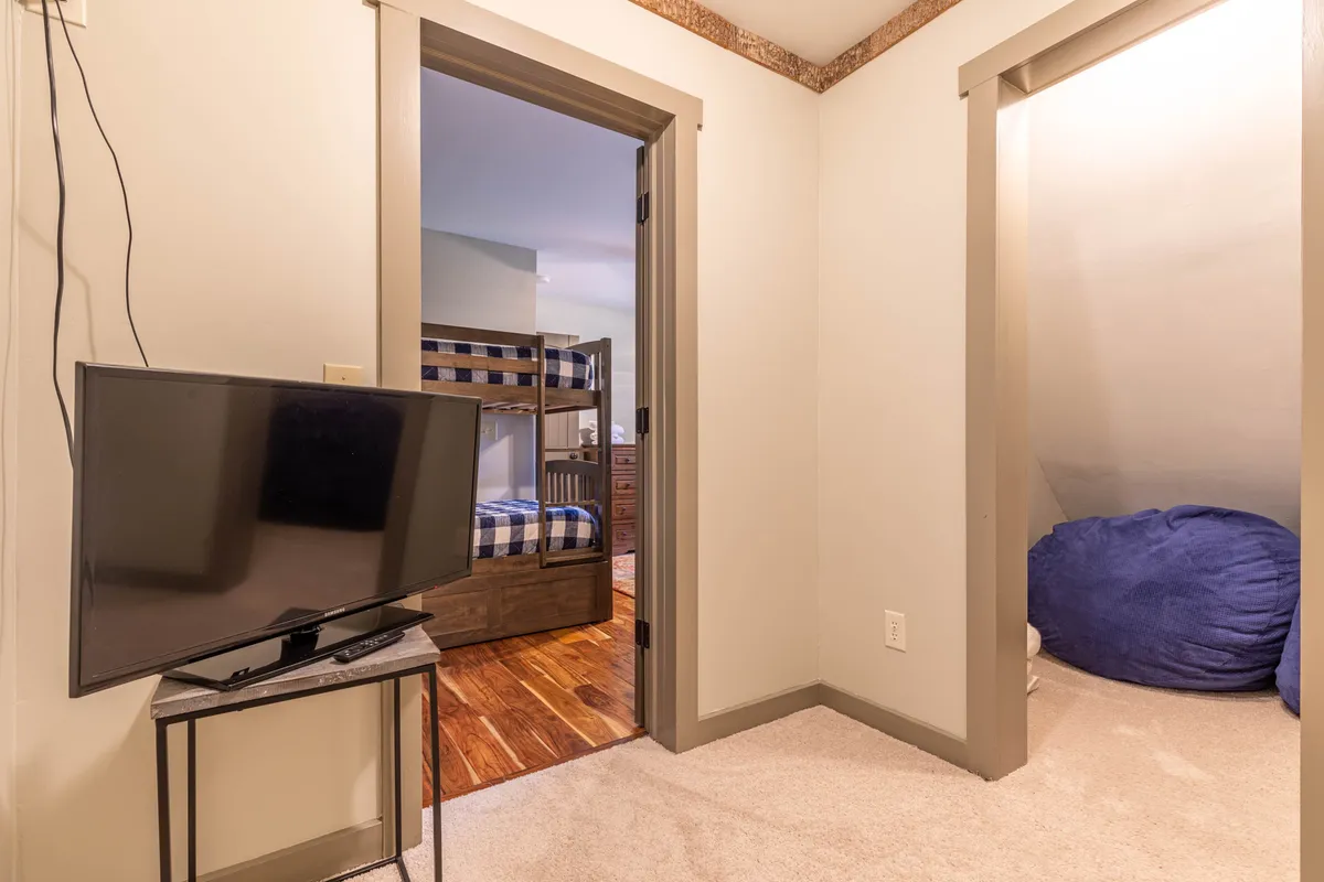 A playful nook featuring a bunk bed, a blue bean bag, and a television. The area is cozy and inviting—ideal for children to read, watch movies, or enjoy a quiet retreat.